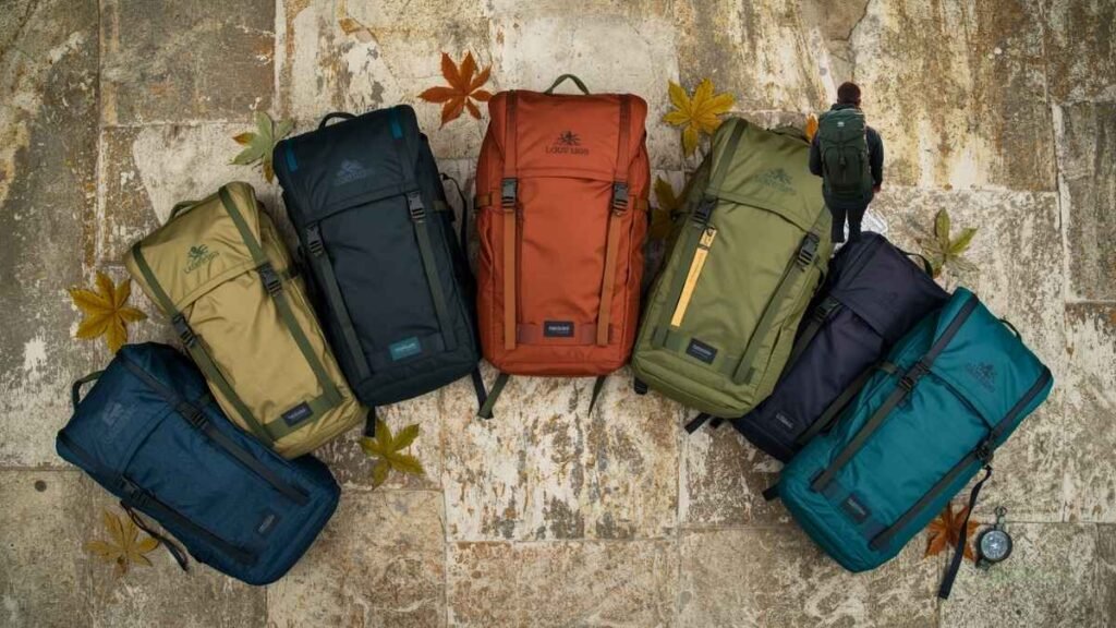 Flat-lay comparison of seven best eco-friendly backpacks for hiking in 2026, recycled and biodegradable materials shown.