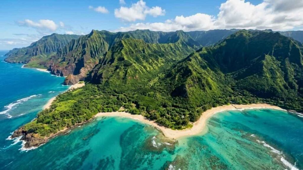 Aerial view of Kauai's north shore showing lush jungle, turquoise reef lagoon, and dramatic sea cliffs on a clear day