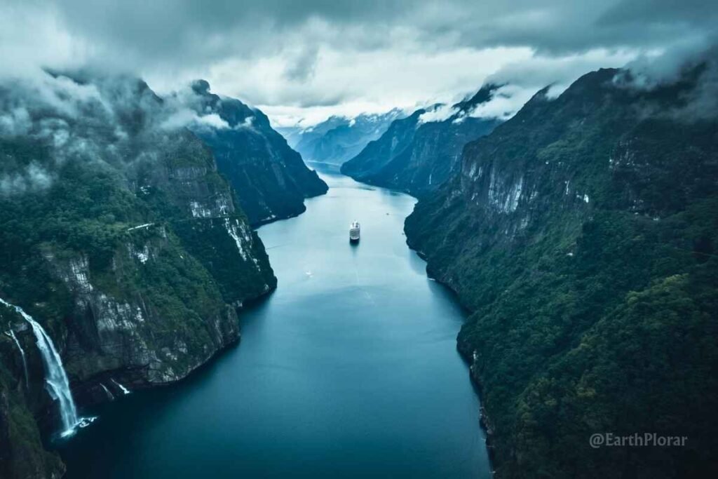 Aerial view of Milford Sound in Fiordland National Park, New Zealand, with sheer fiord cliffs and cascading waterfalls