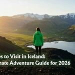 A solo hiker in a green waterproof jacket stands on a volcanic ridge overlooking one of the Best Places to Visit in Iceland at golden hour