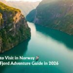 Aerial view of a narrow Norwegian fjord between steep green cliffs, one of the best places to visit in Norway